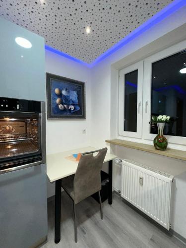 a kitchen with a table and a refrigerator and a counter at Modern Apartments Neuburg D - TOP - 2 Zimmer, Parkplatz, Balkon, Wi-Fi, 2 TV, Dusche, Küche in Neuburg an der Donau