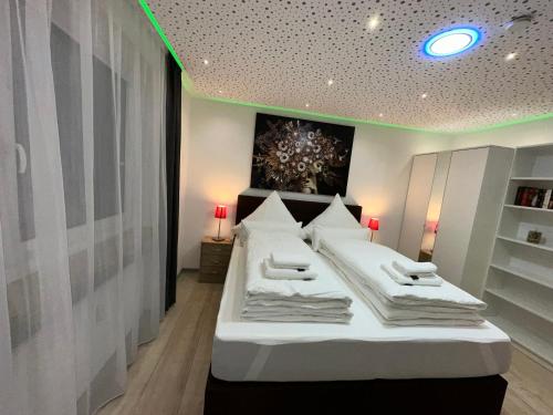 a bedroom with two beds with white pillows at Modern Apartments Neuburg D - TOP - 2 Zimmer, Parkplatz, Balkon, Wi-Fi, 2 TV, Dusche, Küche in Neuburg an der Donau
