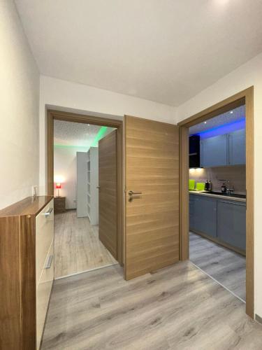 a room with a kitchen and a door to a kitchen at Modern Apartments Neuburg D - TOP - 2 Zimmer, Parkplatz, Balkon, Wi-Fi, 2 TV, Dusche, Küche in Neuburg an der Donau