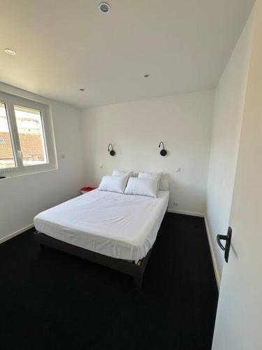 - une chambre avec un lit doté de draps blancs et une fenêtre dans l'établissement Appt de standing centre ville, à Tarbes