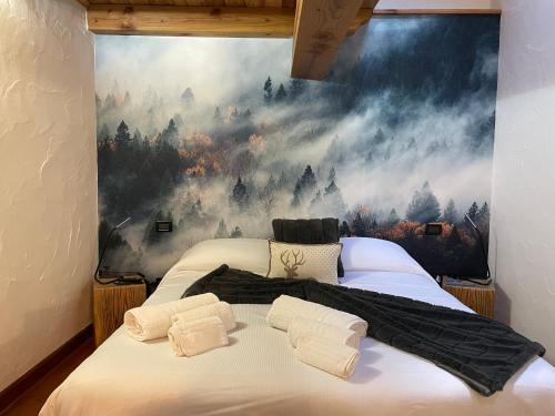 a bedroom with two beds with a painting on the wall at La Chambre des Rêves in Aosta