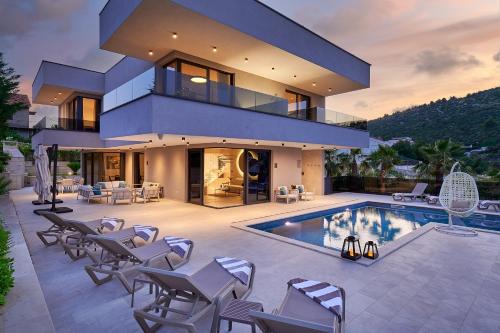 a villa with a swimming pool and a house at Villas Lucy - 1 Lemon -outdoor pool , 2 Cherry-indoor pool and 3 Plum-outdoor pool in Marina
