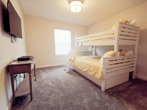 a bedroom with a white bunk bed and a desk at Makin Memories Gated Resort Style Community Storey Lake in Kissimmee