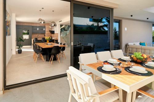 a dining room and kitchen with a table and chairs at Villas Lucy - 1 Lemon -outdoor pool , 2 Cherry-indoor pool and 3 Plum-outdoor pool in Marina