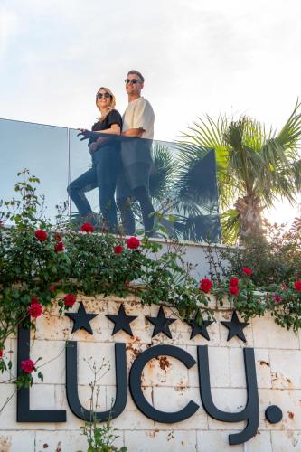 a man and a woman sitting on top of a sign at Villas Lucy - 1 Lemon -outdoor pool , 2 Cherry-indoor pool and 3 Plum-outdoor pool in Marina