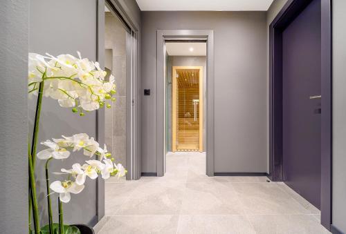 a hallway with purple walls and white flowers in a vase at Villas Lucy - 1 Lemon -outdoor pool , 2 Cherry-indoor pool and 3 Plum-outdoor pool in Marina