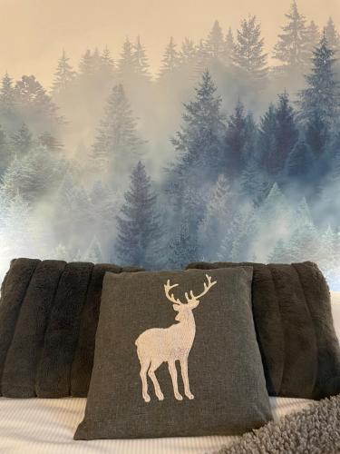 a blanket with a deer on it on a bed at La Chambre des Rêves in Aosta