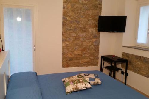 a bedroom with a blue bed and a stone wall at Pietra di Bismantova Short Lets in Castelnovo neʼ Monti