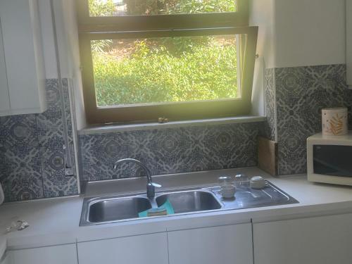eine Küche mit einem Waschbecken und einem Fenster in der Unterkunft Casa del sole in Sperlonga
