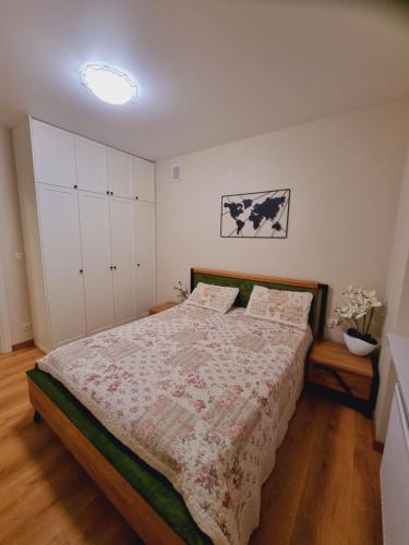 1 dormitorio con 1 cama con colcha de flores en Apartament Solskiego, en Mielec