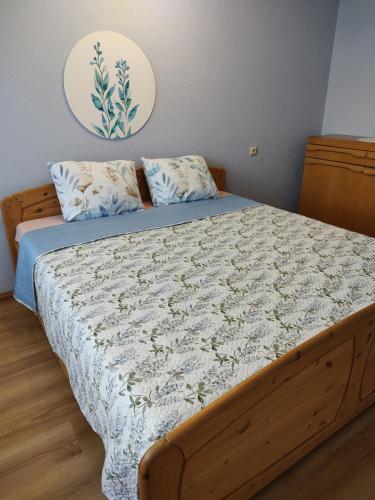 a bedroom with a bed with a blue and white comforter at Rapunselė in Mažeikiai