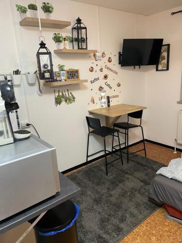 Zimmer mit einem Schreibtisch und einem Tisch mit Stühlen in der Unterkunft Vilseck Apartment in Vilseck