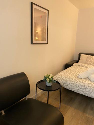 Habitación pequeña con 2 camas y mesa con flores en Luxsuite, en Aubervilliers