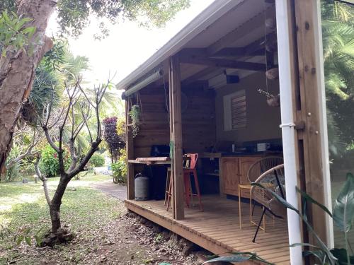 una casa con un porche con una mesa. en Le Niaouli, en Saint-Joseph