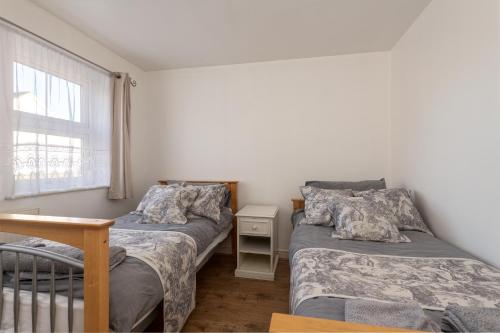 1 dormitorio con 2 camas y ventana en Cosy Retreat - SmartTV and Wi-Fi en Gillingham
