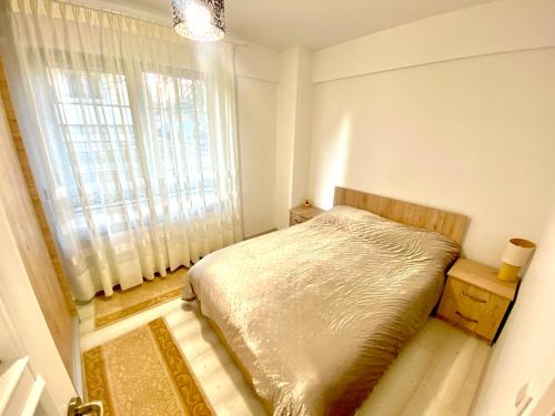 um pequeno quarto com uma cama e uma janela em Apartament Sara em Iaşi