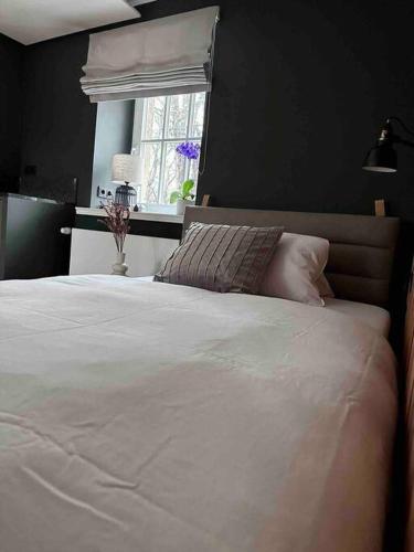 um quarto com uma cama branca e uma janela em Premium Apartment mit Domblick im DG em Paderborn