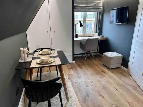uma sala de jantar com mesa e cadeiras e uma secretária em Premium Apartment mit Domblick im DG em Paderborn