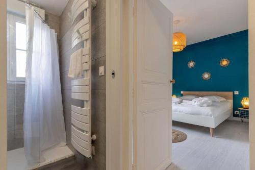 a bedroom with a bed and a blue wall at La Bulle Détente : Maison avec Jacuzzi et Sauna in Montrichard
