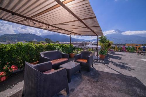 a patio with chairs and tables under a canopy at Hotel Gran Plaza Euromaya in Antigua Guatemala