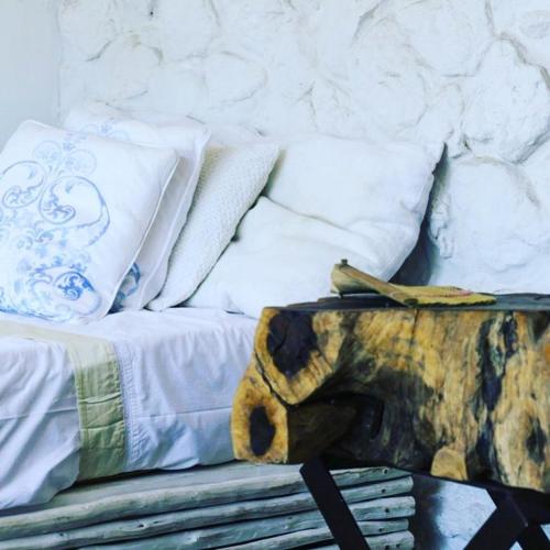 a stuffed elephant sitting on a bed with pillows at Mar-Me-Quer, Eco Beach Retreat in Inhambane