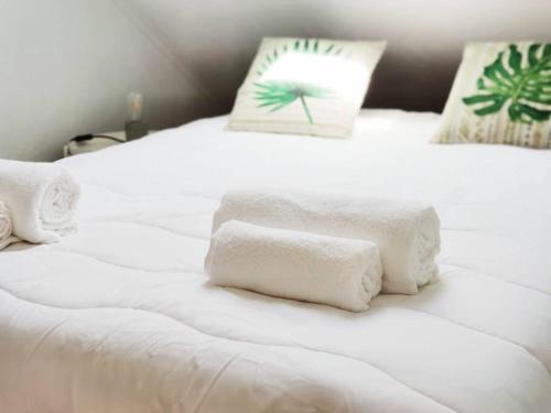 dwa białe ręczniki siedzące na dwóch łóżkach w obiekcie Casinha da Avó w mieście Santiago do Cacém