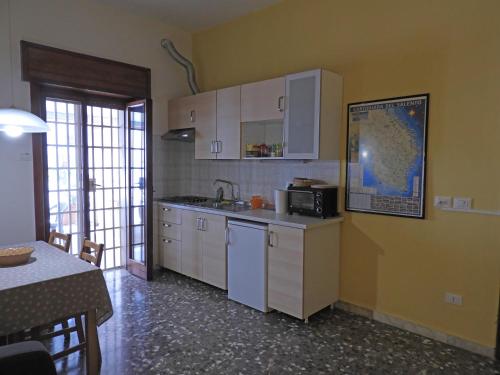 eine Küche mit weißen Schränken und einer Arbeitsplatte in der Unterkunft Oleandro e Glicine in Lecce