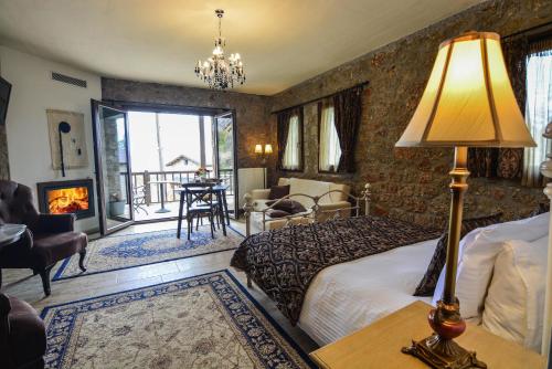 a hotel room with a bed and a fireplace at Trikalon Muses Art Suites in Synikia Mesi Trikalon