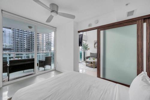 a bedroom with a white bed and a large window at Luxury 2 Bedroom Loft Brickell-WaterViews in Miami