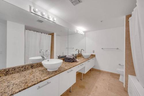 a white bathroom with two sinks and a toilet at Luxury 2 Bedroom Loft Brickell-WaterViews in Miami