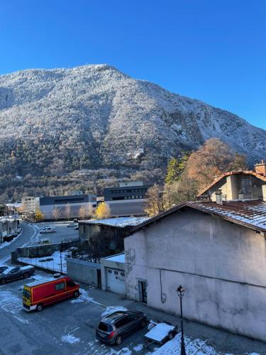 a view of a mountain with cars parked in a parking lot at la Montagnette L ours T1 maison en travaux de 10h a 17h in Moutiers