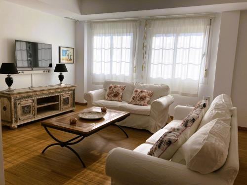 a living room with two white couches and a coffee table at Casa Roja in Almuñécar