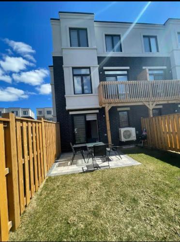 a house with a fence and a table in the yard at Ensuite guest room with separate entrance in Mississauga