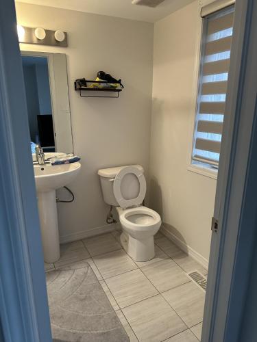 a bathroom with a toilet and a sink at Ensuite guest room with separate entrance in Mississauga