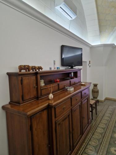 a large wooden entertainment center with a flat screen tv at Jack Room in Trinitapoli