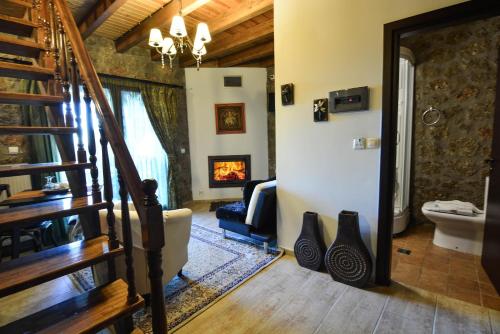 a living room with a staircase and a fireplace at Trikalon Muses Art Suites in Synikia Mesi Trikalon