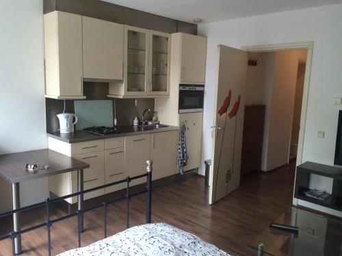 a kitchen with white cabinets and a table in it at Studio Jordaanplein in Amsterdam