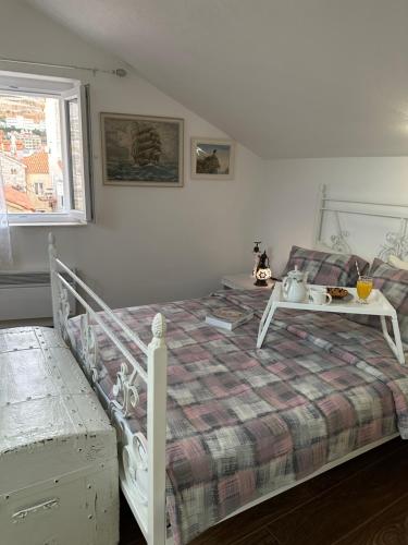 a bedroom with a white bed with a table on it at Apartman Senka in Budva