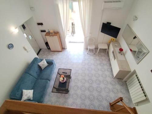 einen Blick über ein Wohnzimmer mit einem blauen Sofa in der Unterkunft Ischia Ponte romantic apartment in the historical center and near the sea in Ischia