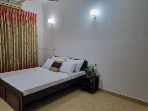sypialnia z łóżkiem z białą pościelą i poduszkami w obiekcie M-stay Colombo w mieście Sri Dźajawardanapura Kotte