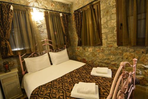 a bedroom with a bed with two towels on it at Trikalon Muses Art Suites in Synikia Mesi Trikalon