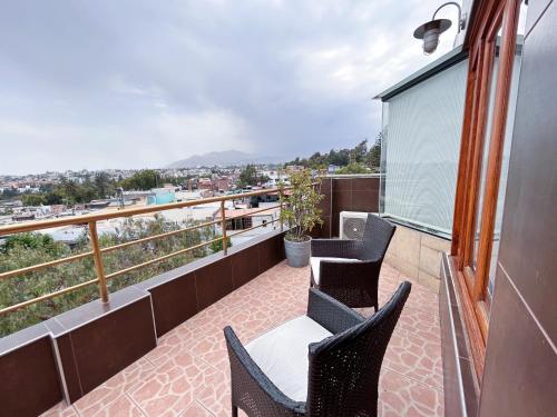 a balcony with chairs and a view of a city at Hotel Fundador by Robles in Arequipa