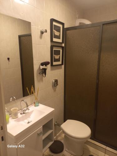 y baño con aseo, lavabo y ducha. en Apto111consuladoamericano, en Porto Alegre