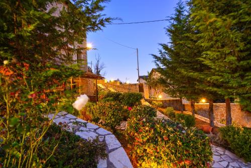 a garden with flowers and trees and a building at Trikalon Muses Art Suites in Synikia Mesi Trikalon
