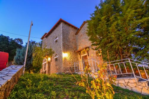 a large brick house with a gate in the yard at Trikalon Muses Art Suites in Synikia Mesi Trikalon