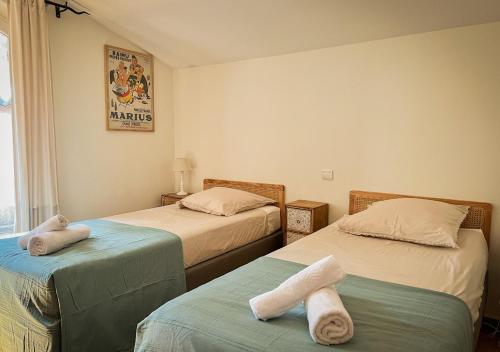 a room with two beds with towels on them at La Villa La Source à Aix en Provence in Aix-en-Provence