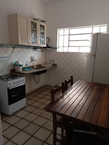 沃爾塔雷東達的住宿－Apartamento MOBILIADO 2 QUARTOS，厨房配有桌子、炉灶和冰箱。