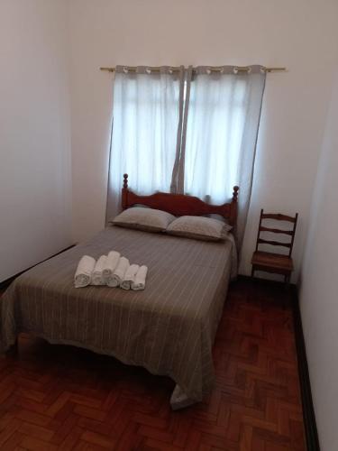 a bedroom with a bed with two slippers on it at Apartamento MOBILIADO 2 QUARTOS in Volta Redonda
