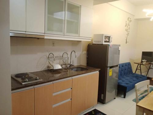 een keuken met een wastafel en een koelkast bij 101 condo furnished walking distance NIAA 3 in Manilla