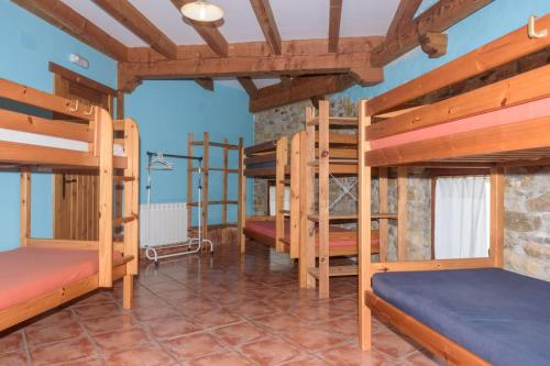 una camera con diversi letti a castello in una casa di Conjunto Rural la Tejedora. Albergue y estudios familiares. a Rasines